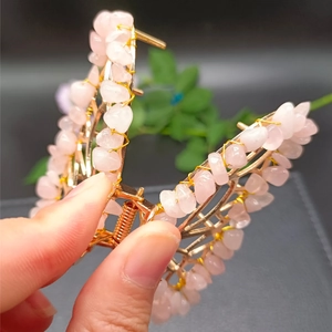 Golden butterfly hair claw with pink crystal stones shown open in a close-up view