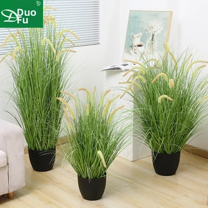 Three artificial potted pampas grass plants in black pots for home decor setting