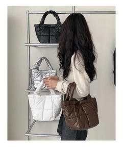 Quilted puffer handbags in black, silver, white, and brown colors with padded handles