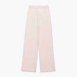 Detailed view of high-waisted beige knitted wide-leg trousers with elastic waistband