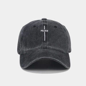 Front view of washed dark grey baseball cap with white PEACE embroidery detail