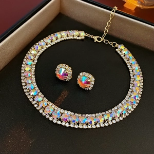 Detail of luxury gold necklace and earrings set with rainbow rhinestones in black box
