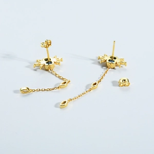 Detailed macro shot of golden S925 earrings with blue gems and elegant long tassels