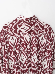 Detail view of ethnic geometric pattern and fabric texture on a vintage short-sleeve shirt