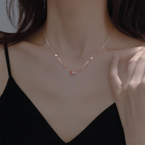 Rose gold clavicle necklace with colorful rings and zircon accents on a model's neck