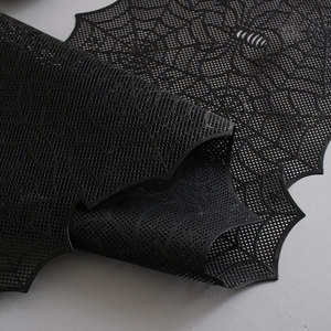 Detail shot of black spider web table runner with intricate hollow lace pattern