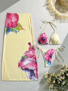 Detailed flat lay of a 3-piece floral bikini set with matching mesh sarong beach skirt