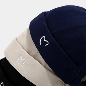 Minimalist cotton docker hats in navy, beige and black with heart embroidery details