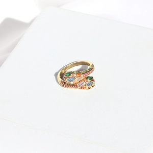 Macro detail of golden snake ring featuring colorful pave crystals in rainbow stones