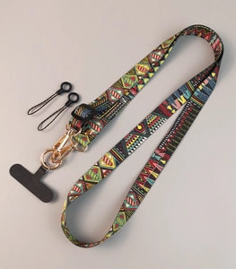 Detailed view of ethnic pattern woven strap with gold metal hooks and plastic connectors