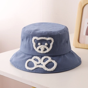 Détail du chapeau de soleil bleu en coton avec broderie d'ours en peluche et large bord