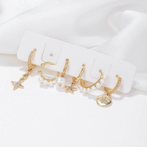 Elegant 6-piece gold earrings set with pearls and star pendants on white silk