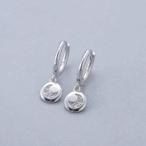 Macro shot of S925 sterling silver hoop earrings with crescent moon zircon pendant