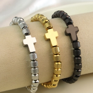 Bracciali con croce in acciaio inox oro, argento e nero su un espositore professionale