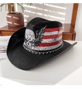 Détail d'un chapeau de cowboy en paille noire avec motif crâne, drapeau US et chaîne