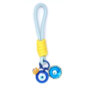 Détail de l'œil bleu tissé et du pendentif éponge jaune sur le porte-clés