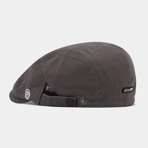 Detail of dark grey beret with adjustable metal buckle strap and since 1991 woven label