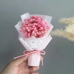 Detail of mini pink dried baby's breath bouquet with mesh wrap and ribbon tie