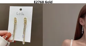 Macro detail of long gold tassel earrings with zircon drop on display card and model