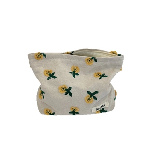 Trousse à maquillage en toile avec broderie florale jaune et fermeture éclair sur le dessus
