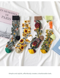 Close-up of four pairs of sheer mesh socks with floral embroidery and ribbed cuffs