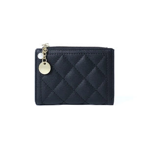 Detail of black quilted leather coin purse with gold zipper and pearl charm