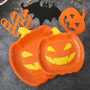 Halloween party tableware featuring orange pumpkin plates and black bat paper decorations