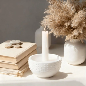 Dettaglio dello stampo a cuore in ceramica bianca con pois in rilievo e candela