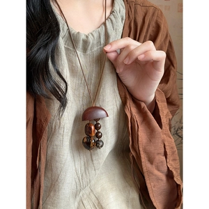 Vue détaillée du collier pendentif en bois fait main au design ethnique rétro