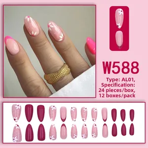 Dettaglio delle unghie a mandorla rosa con motivi floreali bianchi e design French