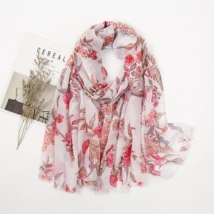 Detail shot of a bohemian pink floral linen scarf with soft frayed edges on white background