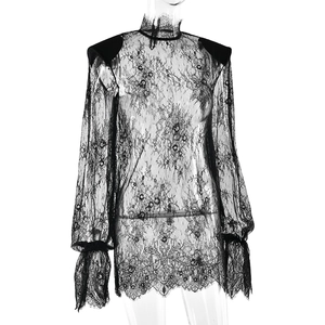 Dettaglio della camicia in pizzo nero trasparente con collo alto e eleganti maniche a sbuffo
