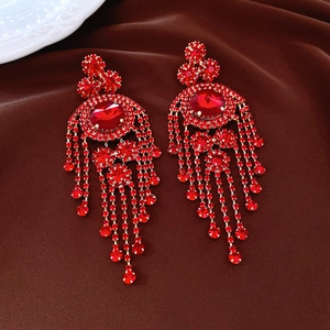 Close-up of vintage deep red tassel earrings with gold-toned rhinestones and fringes
