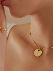 Detailed close-up of a gold-plated 925 silver beaded necklace with star-hollow pendant