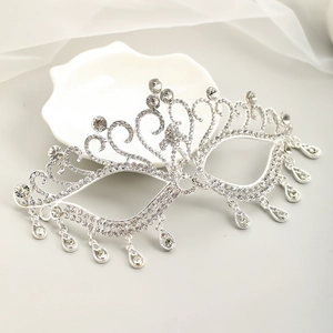 Détail d'un loup de mascarade en strass avec motifs ciselés argentés et pendentifs en poire