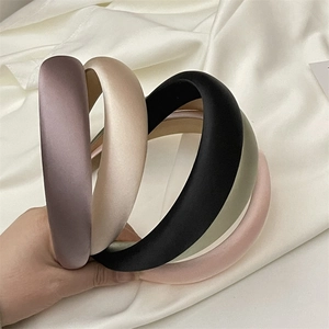 Detail of five padded satin headbands in pastel colors showing smooth glossy texture