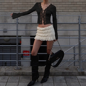 Close-up of the black V-neck lace patchwork top with delicate hook-and-eye buttons