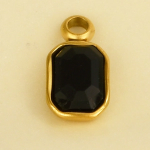 Detail of a golden geometric pendant featuring a black faceted glass stone for DIY jewelry