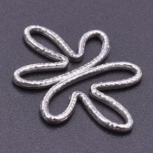 Macro shot of silver stainless steel flower pendant with a unique hammered metal texture