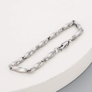 Détail du bracelet à maillons Möbius en acier inoxydable poli avec fermoir mousqueton