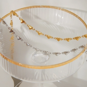 French vintage 18K gold and silver heart chain necklace displayed on glass bowl