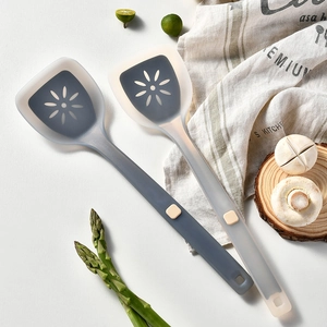Gray and translucent white heat resistant silicone spatulas with flower cutouts on a table