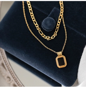 Double-layered gold titanium necklace featuring a black square pendant and Figaro chain