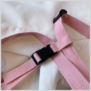 Macro view of a durable pink woven strap with a black plastic side-release buckle detail