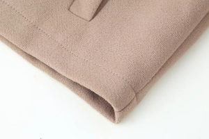 Detailed close-up of premium wool jacket hem with professional double-stitch sewing