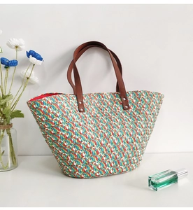 Close-up of colorful straw tote bag with brown leather handles and textured weave