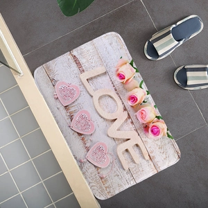 Dettaglio di un tappetino assorbente in flanella con rose rosa e scritte LOVE