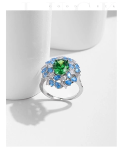 Macro view of vintage silver floral ring with emerald green stone and blue crystals
