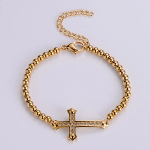 Detail view of gold titanium steel bead bracelet with sparkling zircon cross pendant