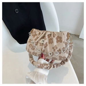 Detail of floral pleated handbag with silver flower chain and retro fabric texture